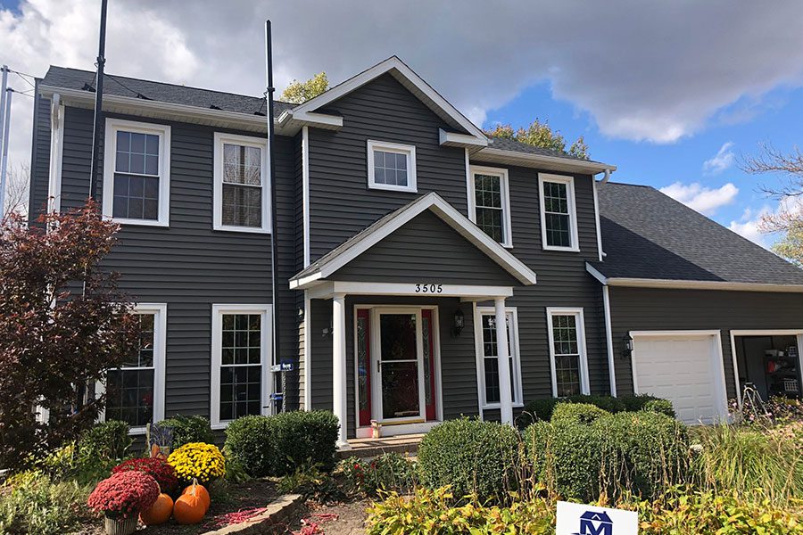 A beautiful two-storyhome in the Quad Cities that has just had new dark grey siding installed by a home improvement company.