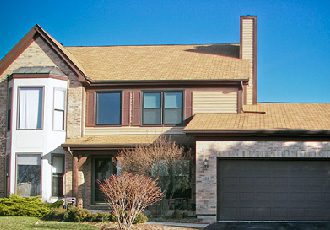 Brand new tan asphalt shingles installed on a residential roof in the Quad Cities. A residential home with new shingles replaced on their roof decking.