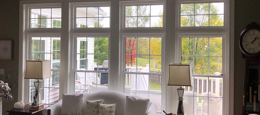 Large double-hung windows for a residential living space in Davenport, IL that has thick white trimming and paned glass.
