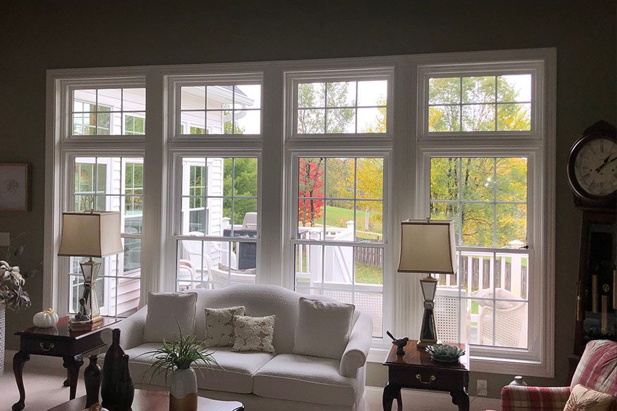 Large double-hung windows for a residential living space in Davenport, IL that has thick white trimming and paned glass.