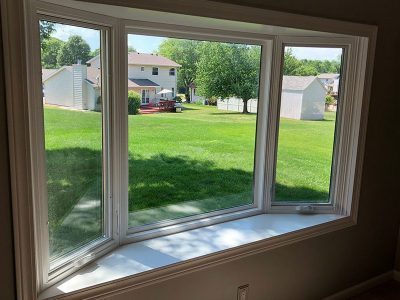 A bay window overlooking a green backyard in a residential home in Bettendorf, IA.