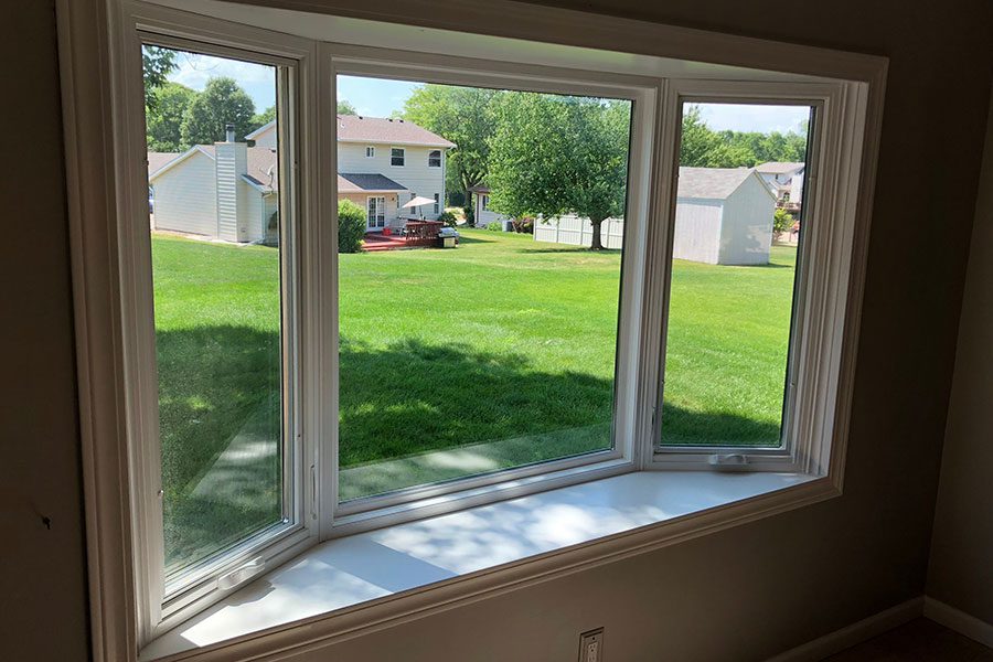 A bay window overlooking a green backyard in a residential home in Bettendorf, IA.