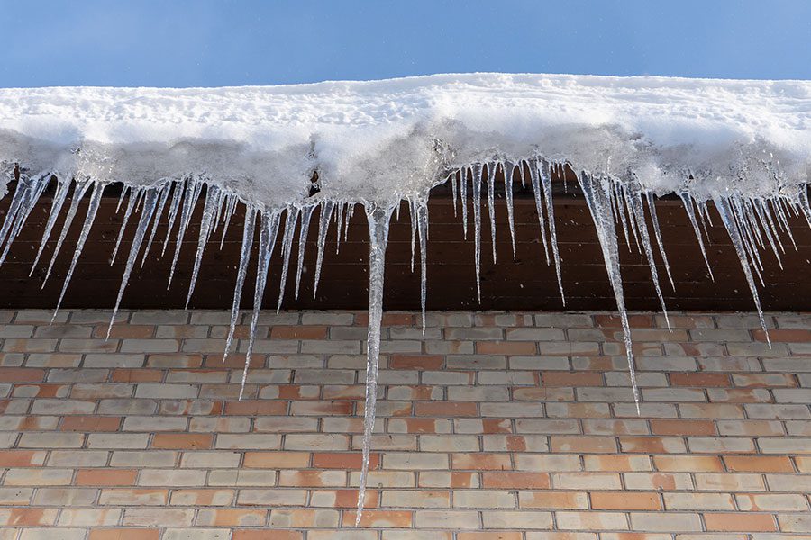Icicles form on the edge of a residence's roof in Bettendorf, IA, posing potential dangers.