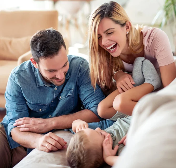 husband and wife playing with young child