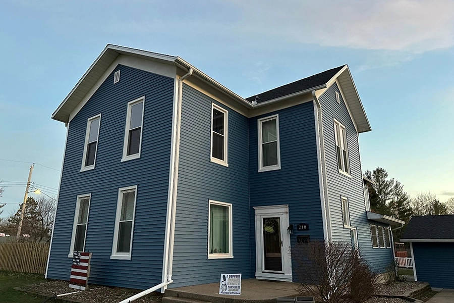 This is a picture of a house with newly installed blue siding by Mainstream Home Improvement.