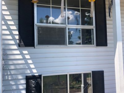 camanche window replacement - exterior windows of two-story white house, before
