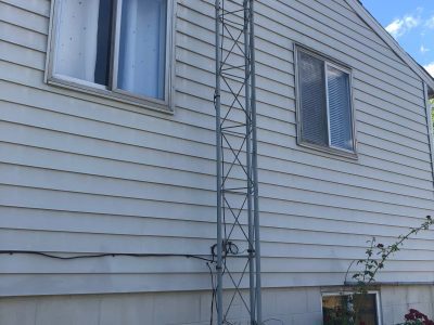 camanche window replacement - exterior back windows of two-story white house, before