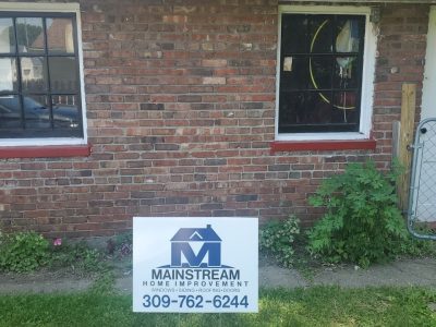 moline window replacement - exterior side of house with company signage, during