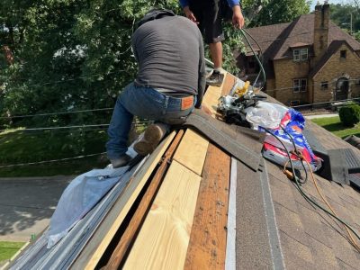 rock island roofing replacement - worker on roof, during