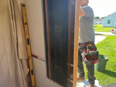 moline window installation - worker fixing outside window frame, during