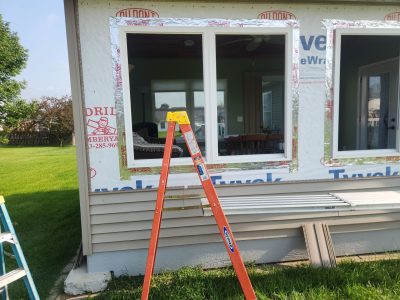 davenport window installation - exterior side of house with ladder and scaffolding, during