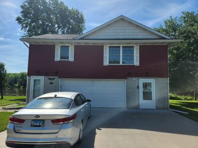 east moline roofing replacement - exterior driveway view of red two-story house, before