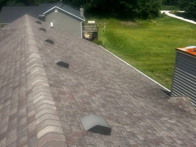 blue grass roofing installation - peak of old grey roof, before