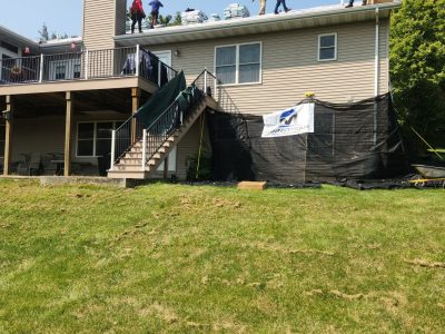 blue grass roofing installation - several workers on working on new roof install, during