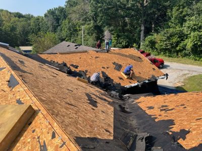 blue grass roofing installation - workers installing new roof boards, during