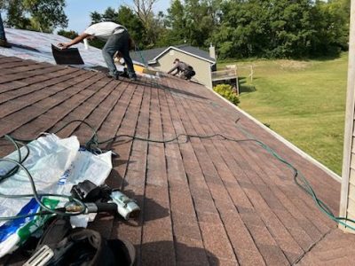 blue grass roofing installation - workers removing old roof shingles, during