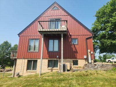milan siding replacement - exterior back of house with new red siding, after