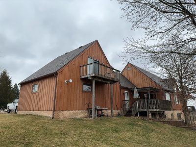 milan siding replacement - side yard view of two-story house, before