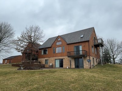milan siding replacement - backyard view of two-story house, before