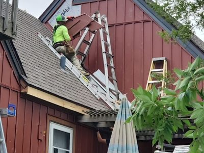 milan siding replacement - contractor installing red siding, during