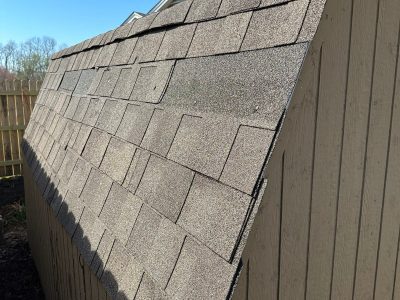 davenport roofing replacement - side of shed with shingle damage, before