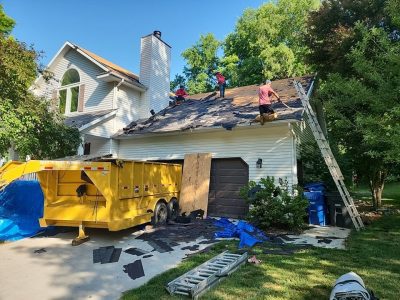 moline roofing replacement - contractors removing old roof pieces, during