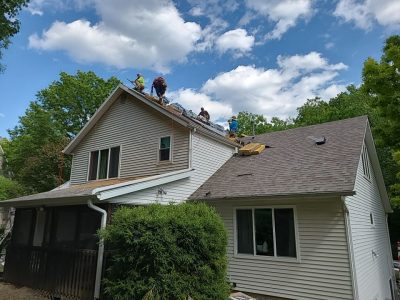 moline roofing replacement - contractors working on peak of roof, during