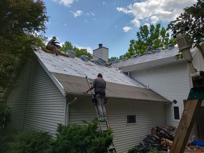 moline roofing replacement - contractors removing old roof pieces of garage, during