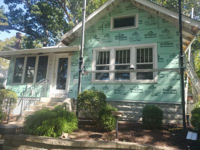 rock island roofing replacement - front of house new siding being installed, during