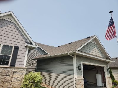 davenport roofing replacement - front yard view of tan house with new roof, after