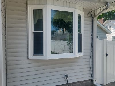 moline window installation - exterior left side view of new white bay window, after