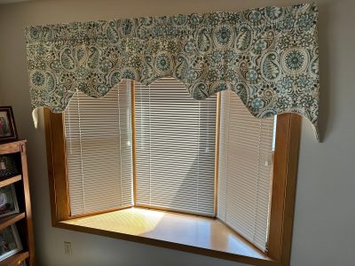 moline window installation - inside view of large bay window with blinds and curtains, before