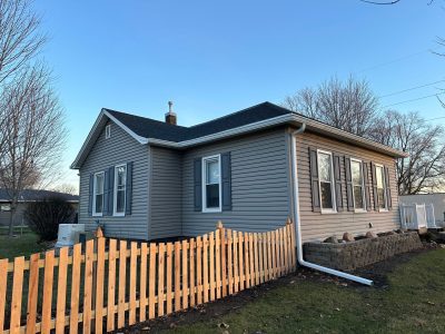 aledo roofing installation - side view of new black roof on tan house, after