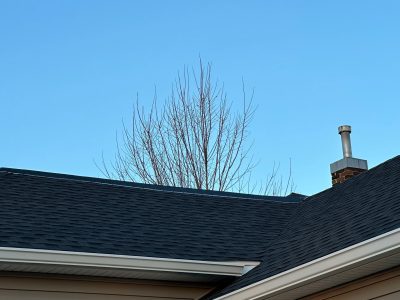 aledo roofing installation - close-up of corner of house with new black roof, after