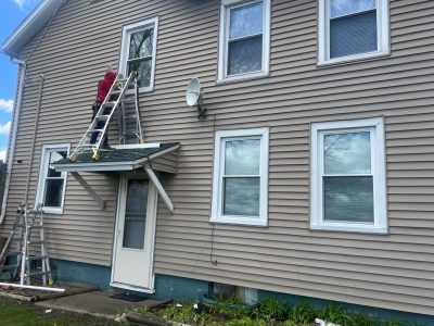 orion window replacement - worker on ladder installing new window, during