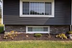 milan siding replacement - front of house with new navy siding and stone, after