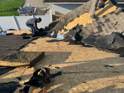 milan roofing installation - workers removing old roof tiles, during