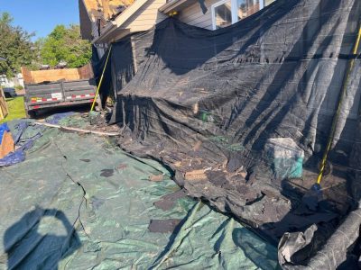 milan roofing installation - workers removing old roof shingles, during