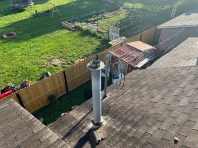 milan roofing installation - old broken roof shingles around heating system, during