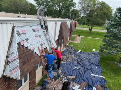 silvis roofing installation - contractors working on side of church, during