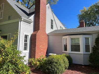 rock island roofing installation - side of house with fireplace and new gray siding/black roof, after - 2