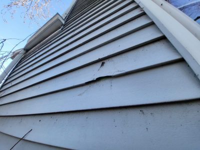 rock island roofing installation - chipped piece of siding on house, before