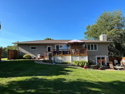 orion roofing replacement - backyard view of large two-story house, before