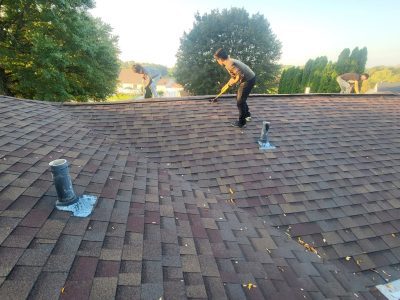 orion roofing replacement - contractor measuring work on roof, during