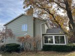 davenport siding installation - side view of two-story house with new dark tan siding, after