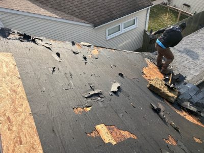 moline roofing installation - contractors removing old boards from roof, during