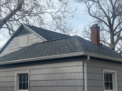 rock island roofing installation - corner view of gray house with new black roof, after