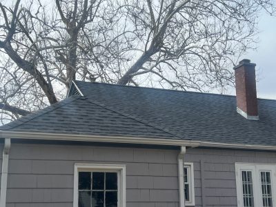 rock island roofing installation - backyard view of gray house with new black roof, after