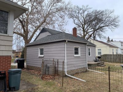 rock island roofing installation - corner view of small gray house, before