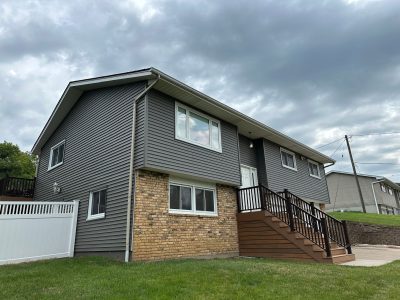 taylor ridge siding installation - front left corner view of two story-house with new dark gray siding, after
